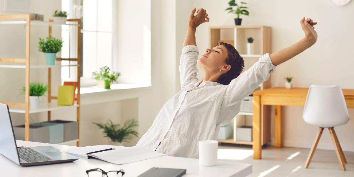 A woman stretches and takes a deep breath in her light and airy home