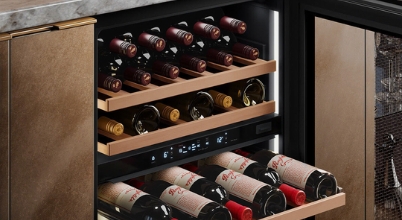 A close-up of a Vintec brand wine fridge with the door open displaying wine collection