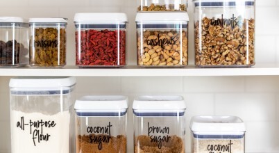 A selection of dried foods in labelled clear jars in a kitchen pantry