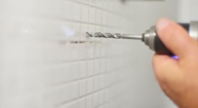 Drilling into tiled walls requires masonry drill bits and skill.