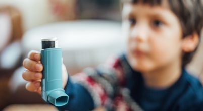 A boy holds an asthma puffer inhaler